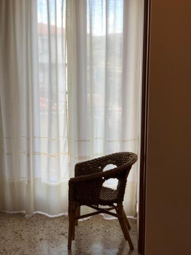 a chair sitting in front of a window at Albergo BELVEDERE in Santa Cristina Gela