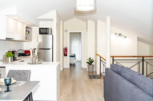 a kitchen and a living room with a couch at Panoramic Attic by Sabugo House in Relógio do Poiso