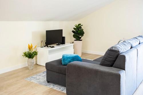 a living room with a couch and a tv at Panoramic Attic by Sabugo House in Relógio do Poiso