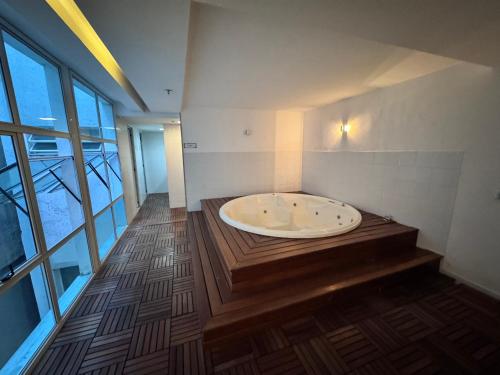 a bath tub in a room with a large window at Lapa reformado melhor localização in Rio de Janeiro