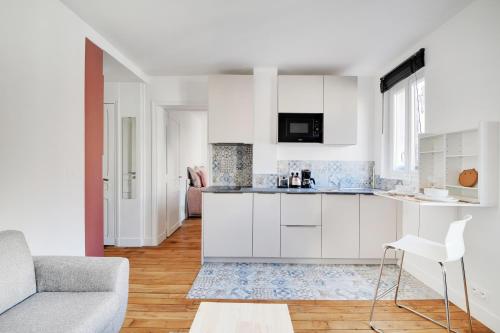 - une cuisine blanche avec un canapé et une table dans l'établissement Pantheon - Quartier Latin, à Paris