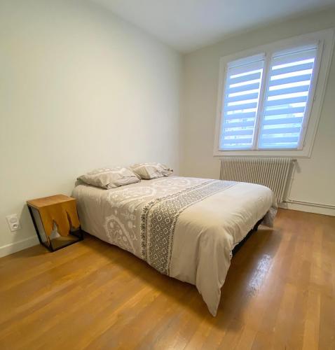 une chambre avec un lit et une grande fenêtre dans l'établissement Appart cozy - 2 chambres, à deux pas du centre ville, à Chalon-sur-Saône