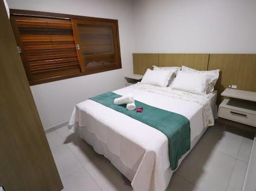 a bedroom with a large bed with two towels on it at Hospedagem Nonna Adélia in Nova Veneza