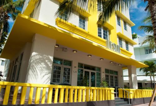 a yellow building with a fence in front of it at Leslie Hotel Ocean Drive in Miami Beach