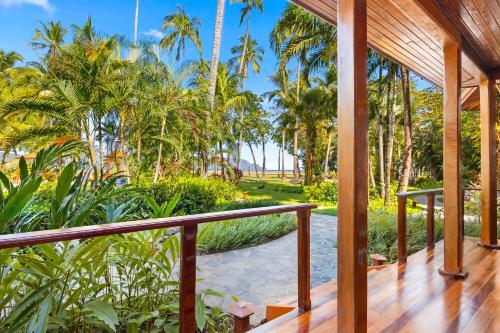 a porch of a resort with palm trees at Tambor Tropical Beach Resort- Adults Only in Tambor