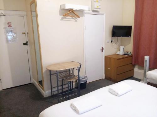 a room with two beds and a table and a stool at Victorin House - All rooms are EN-SUITE in Portsmouth