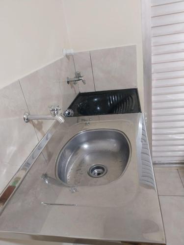 a stainless steel sink in a corner of a room at APT Raphis C in Santarém