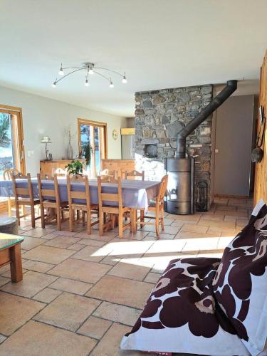 - un salon avec une table et une cheminée en pierre dans l'établissement Chalet Au Bois Joli - Chalet 4 pour 8 personnes exposé Sud-Est MAE-5141, à Valloire