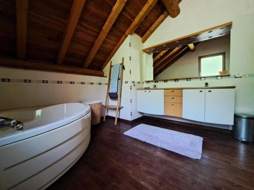 une grande salle de bain avec une baignoire et un lavabo dans l'établissement Chalet Au Bois Joli - Chalet 4 pour 8 personnes exposé Sud-Est MAE-5141, à Valloire
