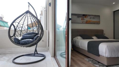 a swing chair in a bedroom with a bed at CC LUX Suites in Piraeus
