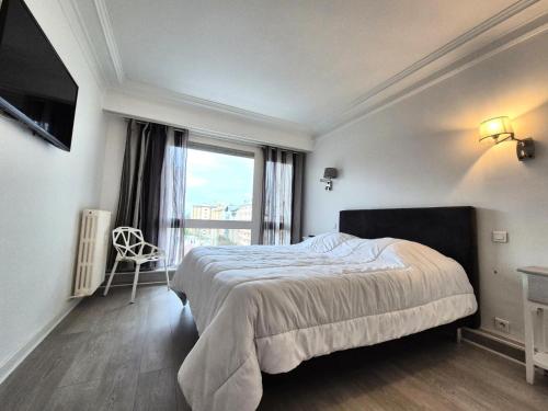 une chambre avec un lit et une grande fenêtre dans l'établissement Résidence Le Constellation - Logement spacieux au coeur ville d'Aix les Bains ! MAE-6394, à Aix-les-Bains