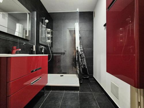 une salle de bain avec des armoires rouges et une baignoire dans l'établissement Résidence Le Constellation - Logement spacieux au coeur ville d'Aix les Bains ! MAE-6394, à Aix-les-Bains
