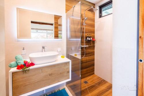 a bathroom with a sink and a shower at Villa Vanaki - Beachfront Villa 4BR w AC in Moorea