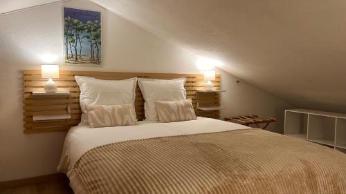 une chambre avec un grand lit avec deux lampes dans l'établissement L'Atlantide Maison & Spa - Accès direct à la plage, à Saint-Hilaire-de-Riez