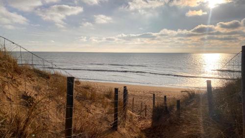una spiaggia con recinzione e oceano di L'Atlantide Maison & Spa - Accès direct à la plage a Saint-Hilaire-de-Riez