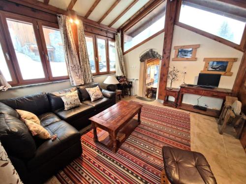 a living room with a leather couch and a coffee table at Chalet Rianne - Beau chalet 8/10 personnes MAE-9554 in Modane
