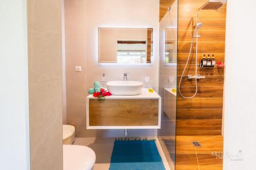 a bathroom with a sink and a toilet at Villa Vanaki - Beachfront Villa 4BR w AC in Moorea