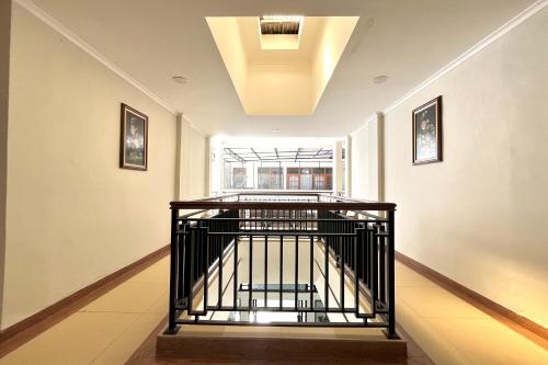a hallway with a spiral staircase in a building at Maison Hotel Bukittinggi in Bukittinggi