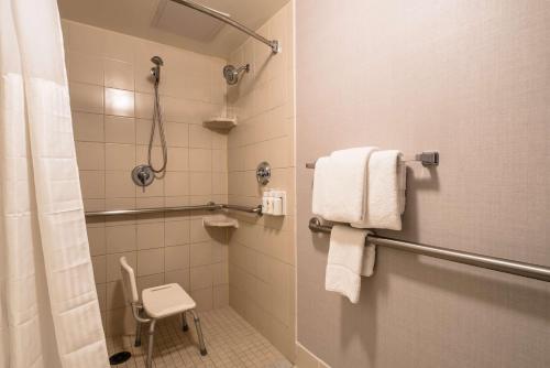 a bathroom with a shower and a toilet and towels at Sonesta Select Dallas Richardson in Richardson