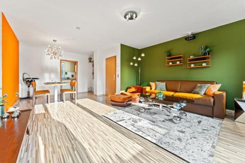 a living room with a brown couch and a green wall at 3 Zimmer, Beamer, Balkon, Disney Plus in Woltersdorf