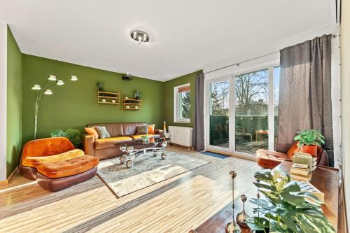 a living room with green walls and leather furniture at 3 Zimmer, Beamer, Balkon, Disney Plus in Woltersdorf