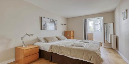 - une chambre avec un lit et une lampe sur une table de chevet dans l'établissement Spacious Contemporary Flat in the 15th - Mid-T, à Paris