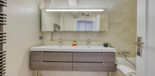 une salle de bain avec un lavabo et un miroir dans l'établissement Spacious Contemporary Flat in the 15th - Mid-T, à Paris