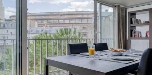 une table de salle à manger avec vue sur un balcon dans l'établissement Spacious Contemporary Flat in the 15th - Mid-T, à Paris