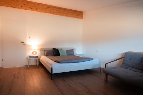 a bedroom with a bed and a chair at Hohenzollern Wellness Loft mit Panorama Sauna in Burladingen