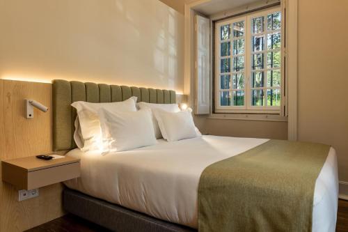 a bedroom with a large bed with a window at CICIOSO boutique hotel in Évora