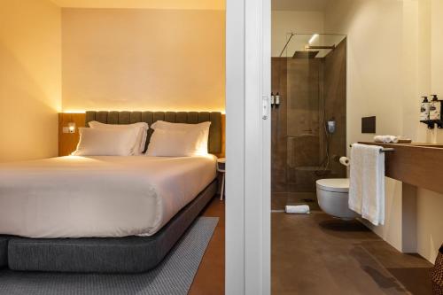 a hotel room with a bed and a bathroom at CICIOSO boutique hotel in Évora