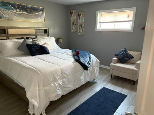 a bedroom with a large white bed and a chair at Memphis Getaway in Memphis