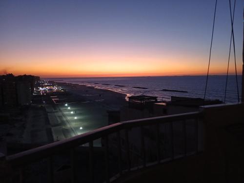 a view of a beach at sunset from a balcony at Flores casas de playa in Alexandria