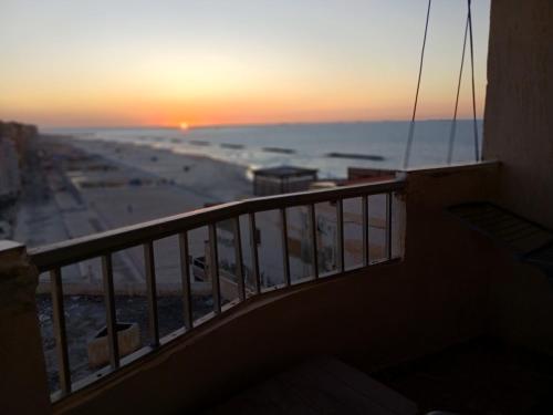 a balcony with a view of the beach at sunset at Flores casas de playa in Alexandria