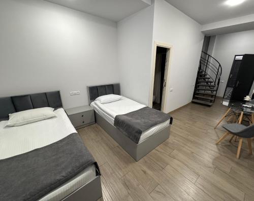 a bedroom with two beds and a television in it at Lux Plaza in Pʼarakʼar