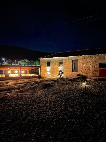a building in the middle of a field at night at Solar do Prazo in Gonçalo
