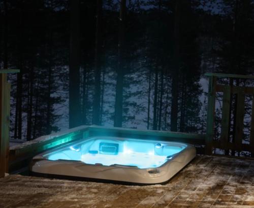a jacuzzi tub on the deck of a house at Hossaville Luxe Lake Cabin in Hossa