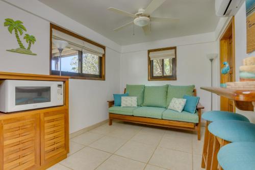a living room with a couch and a tv at Bella Sway Belize in Maya Beach