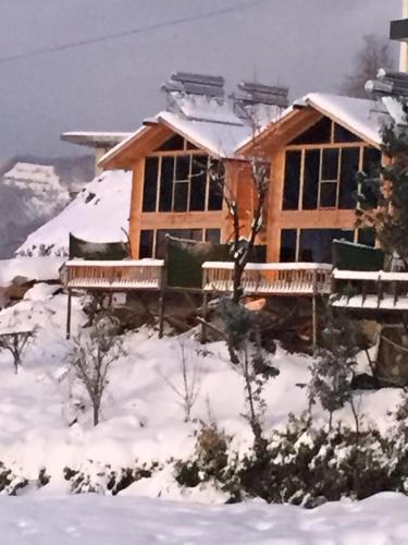 a wooden house in the snow with snow at Parla dağ evi kırmızı oda in Çamlıhemşin