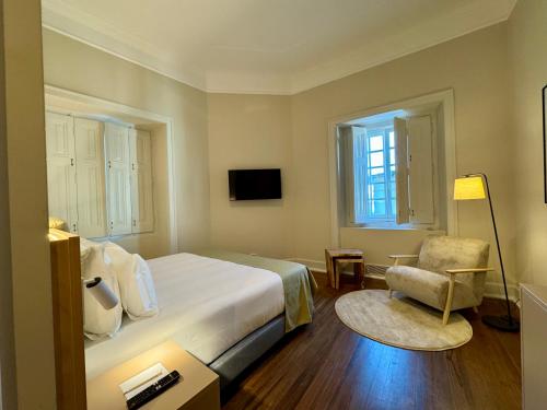 a hotel room with a bed and a chair at CICIOSO boutique hotel in Évora