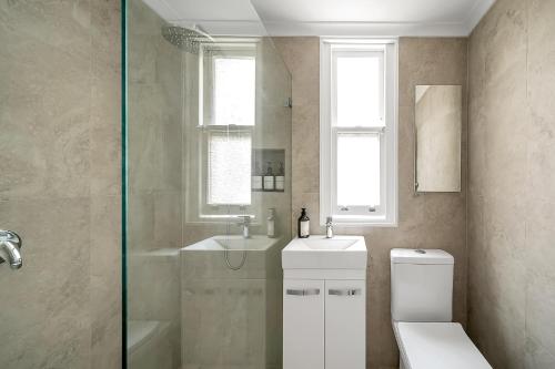 a bathroom with a toilet and a sink and a shower at Renovated Harbourfront Home With Harbour Views in Sydney