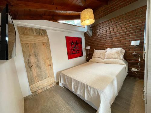 a bedroom with a bed and a brick wall at La comarca 1 in Villa Gesell