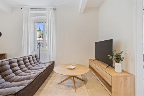 a living room with a couch and a tv at Modern Apartments in Clausen with WiFi, Kitchen & Workspace in Luxembourg