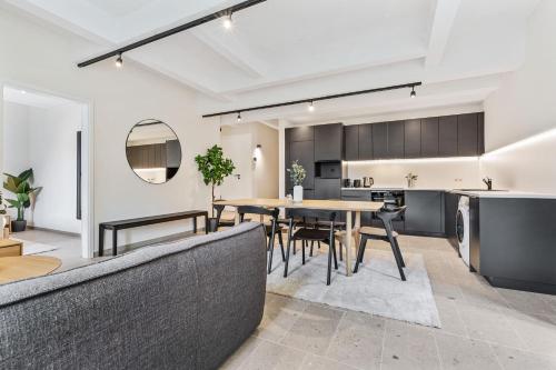 an open kitchen and dining room with a table and chairs at Modern Apartments in Clausen with WiFi, Kitchen & Workspace in Luxembourg