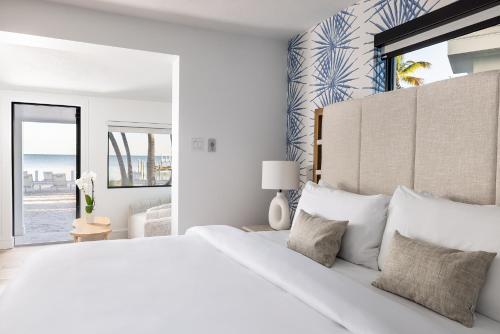 a white bedroom with a large bed and a window at Pines & Palms Resort in Islamorada