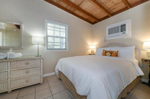 a bedroom with a large white bed and a dresser at Pines & Palms Resort in Islamorada