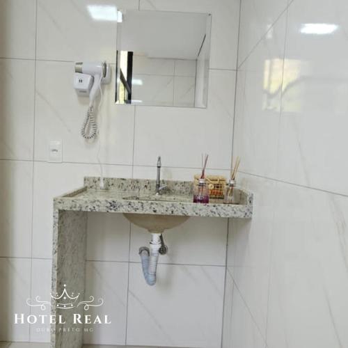 a bathroom with a sink and a mirror at Hotel Real in Ouro Preto
