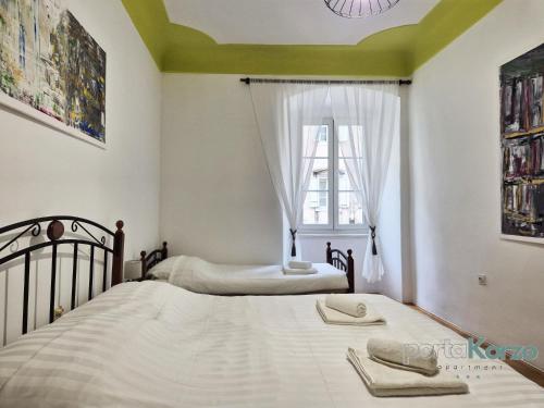 リエカにあるPortaKorzo Center Apartmentのツインベッド2台 窓付きのベッドルーム1室