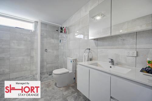 a bathroom with a white toilet and a sink at Conservatorium Villa 2 in Orange