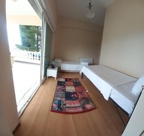 a small room with a bed and a rug on the floor at Gökçen Çiftliği Pansiyon in Eceabat